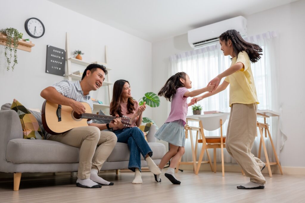 Family enjoying comfortable temperatures in their living room thanks to their ductless mini split AC